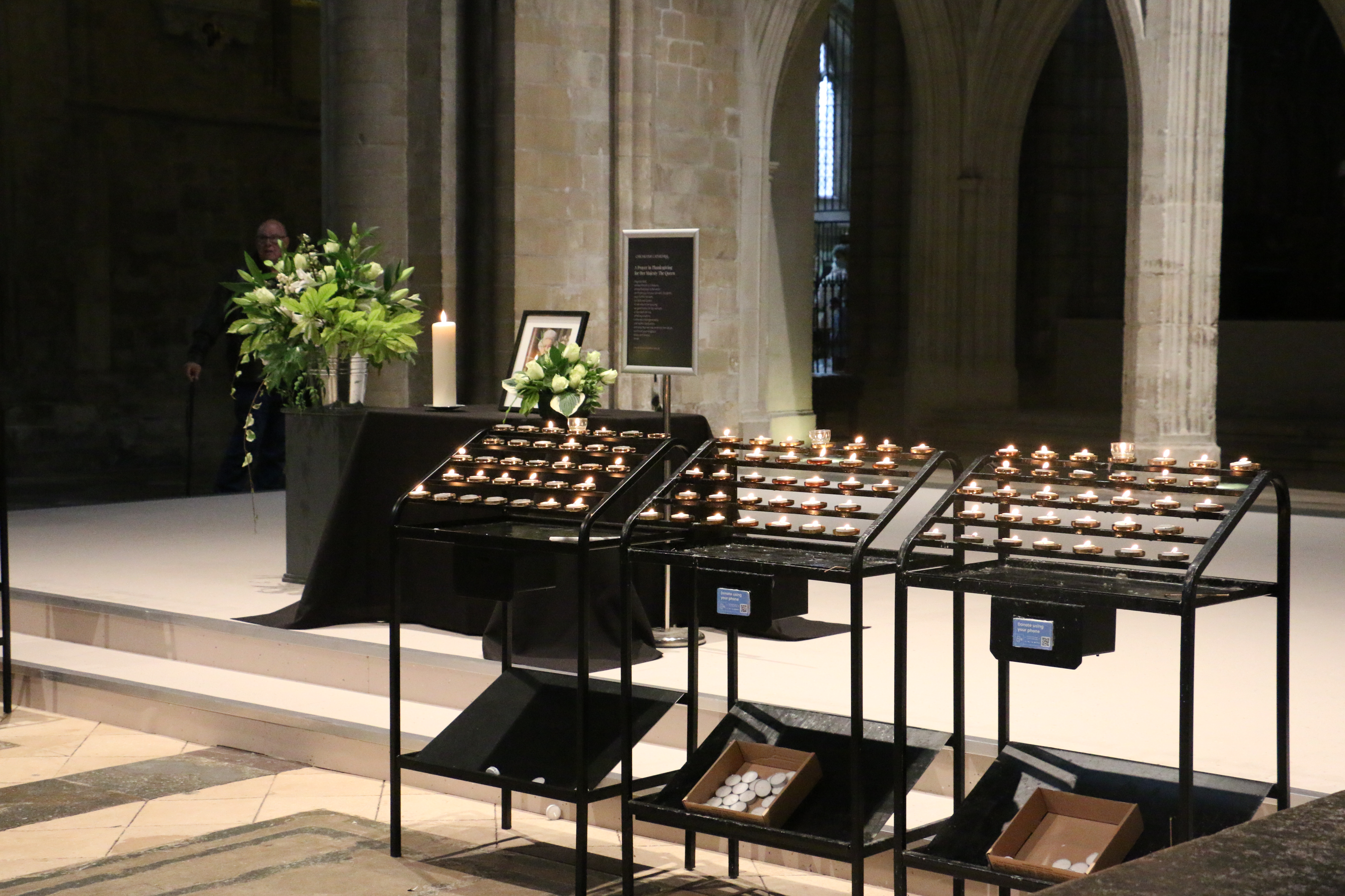 Votive stands hold lit candles in the Nave
