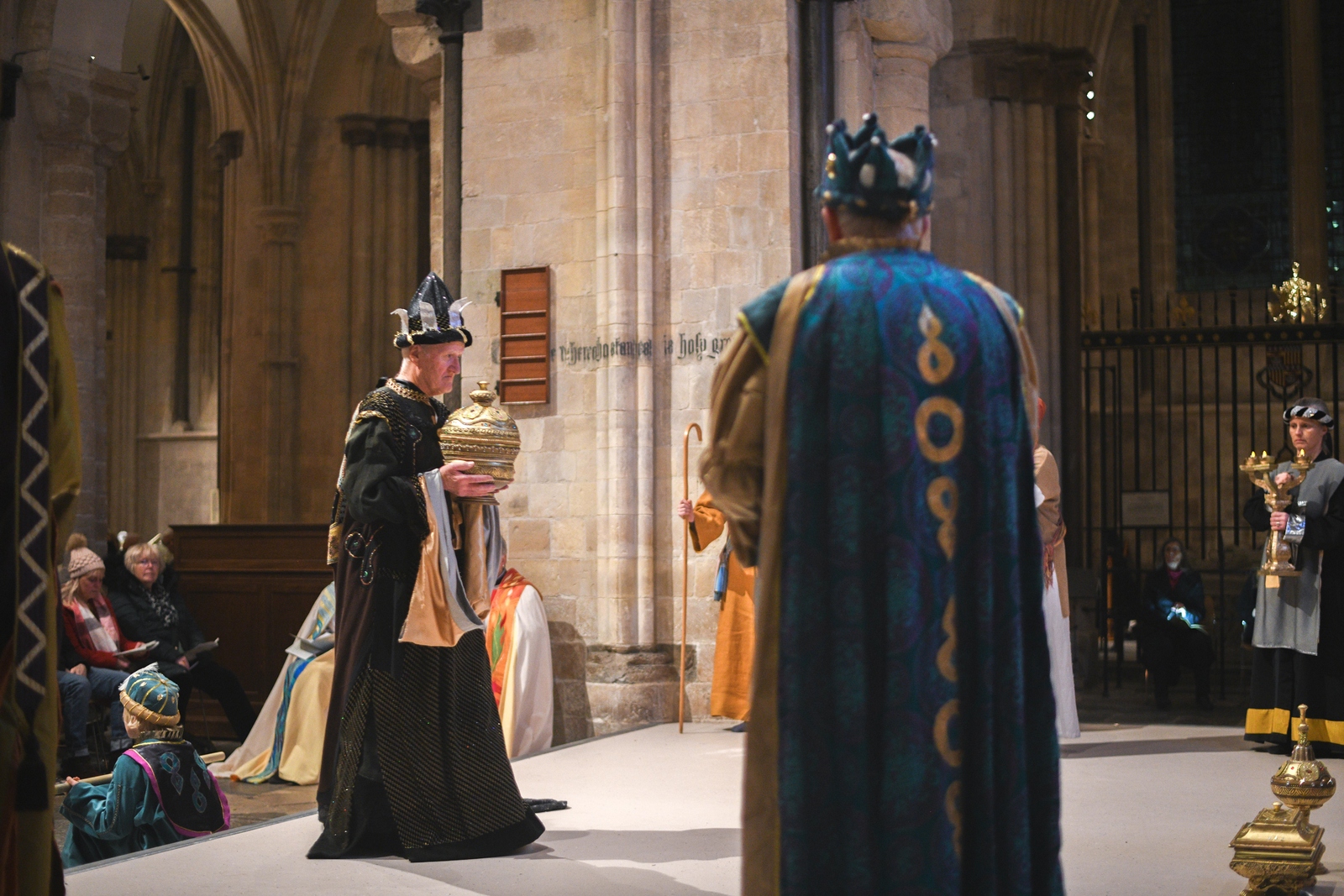 A Magi dressed in black robes carries a gift to the Arundel Screen
