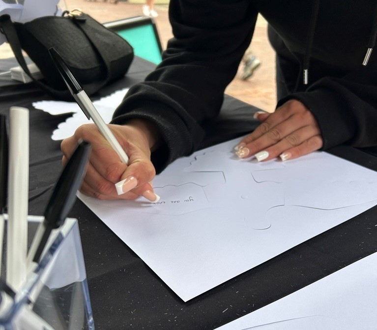 A person writing a message on a paper dove