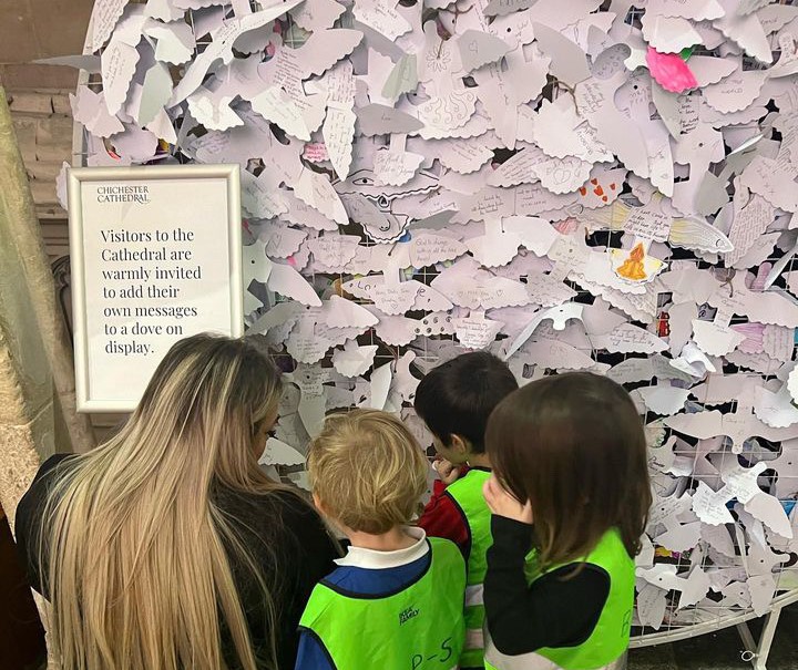 Children look at Peace Doves written by the public