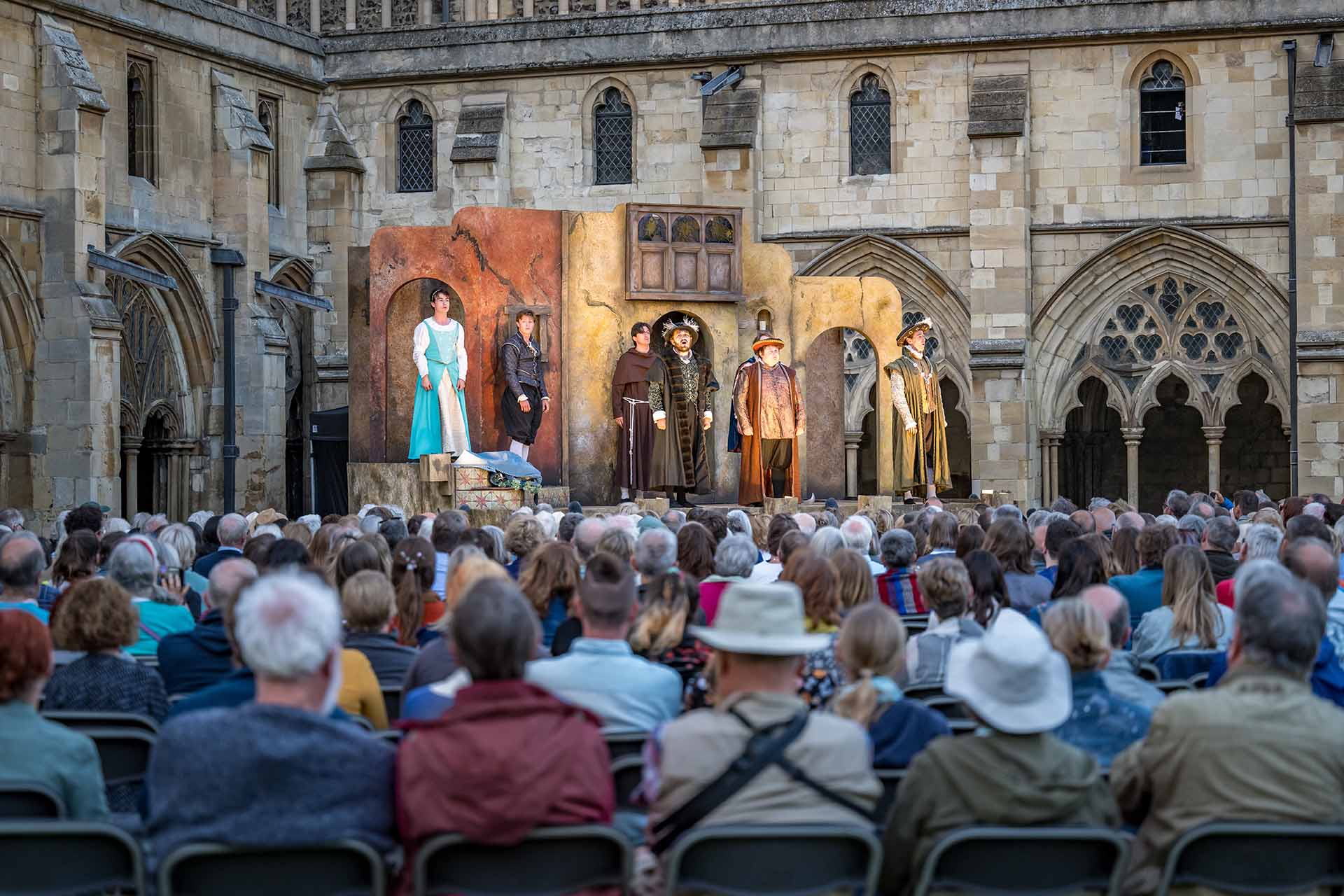 The Lord Chamberlain's Men perform  on stage with a large crowd 