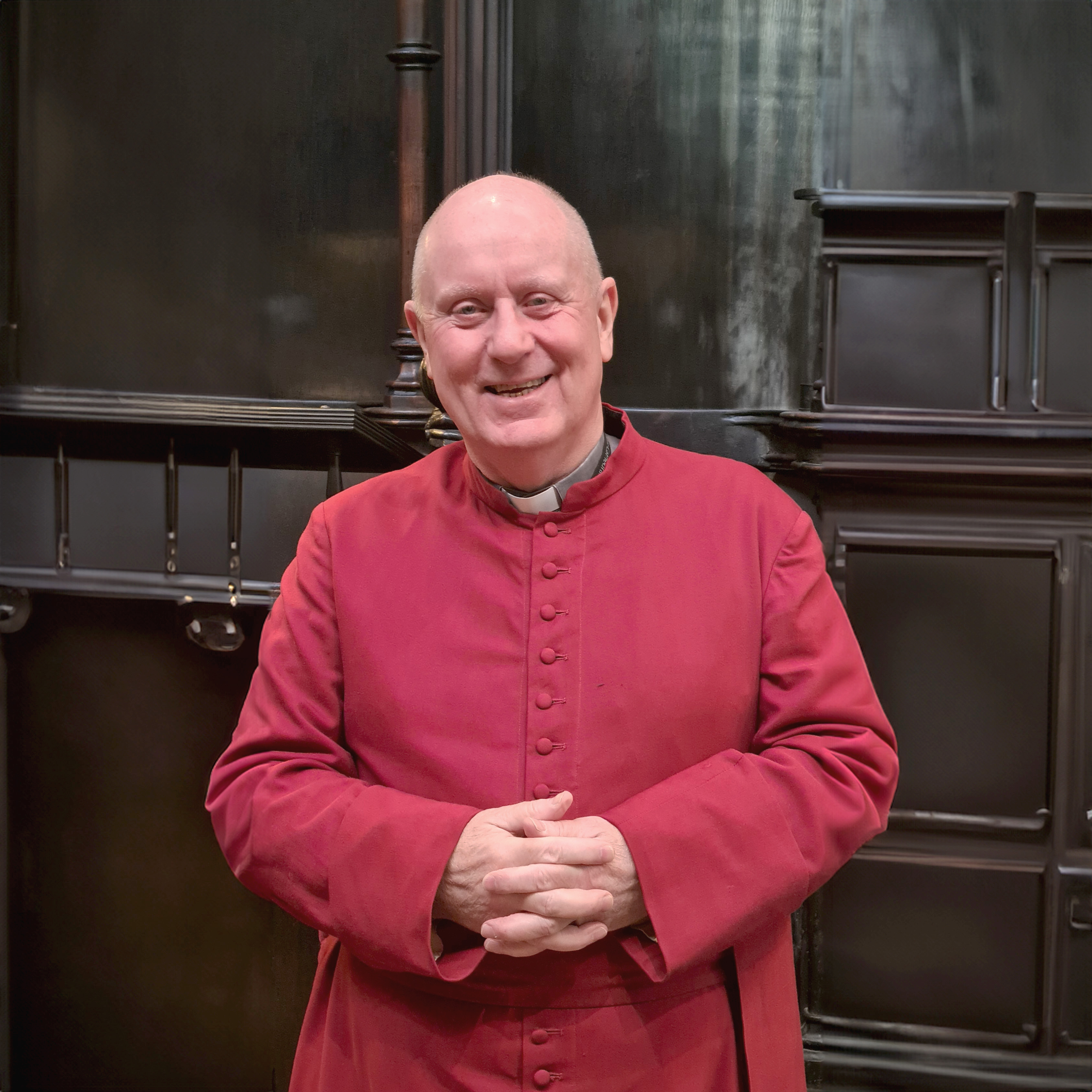 Canon Nigel stood in a red cassock