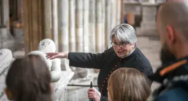 A priest shows children the Arundel Tomb