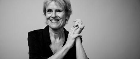 A black and white photo of a woman smiling to camera