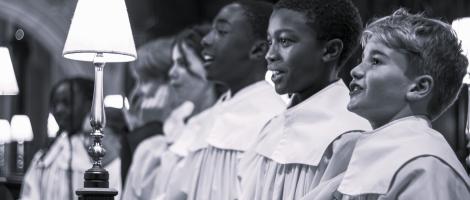 B&W photo of choristers singing in cathedral setting