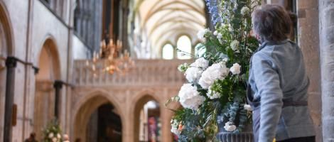 A flower arranger arranging a white floral display