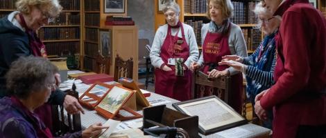 Cathedral librarians sit around a table full of old books