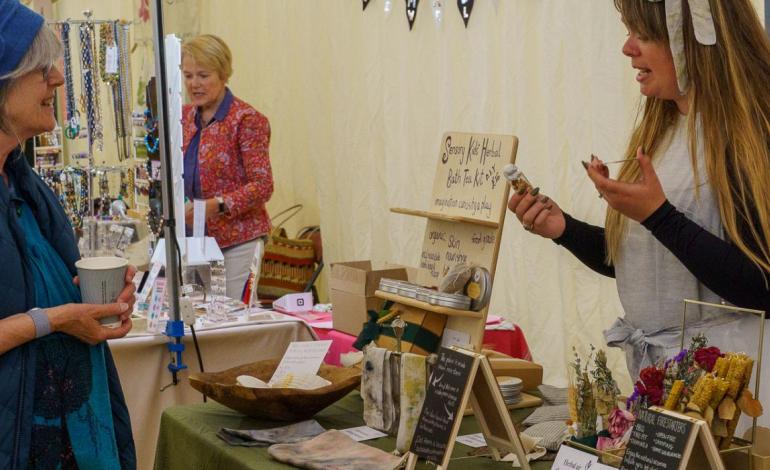 a woman and a customer at a skincare stand