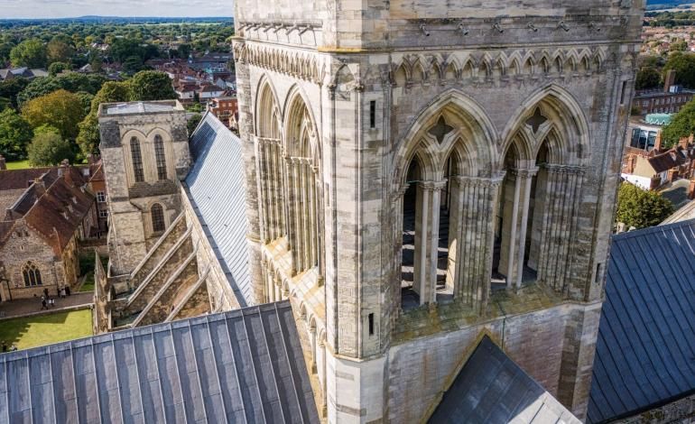 View of Chichester Cathedral's Lantern and roof from above, with the city of Chichester and surrounding countryside beyond.