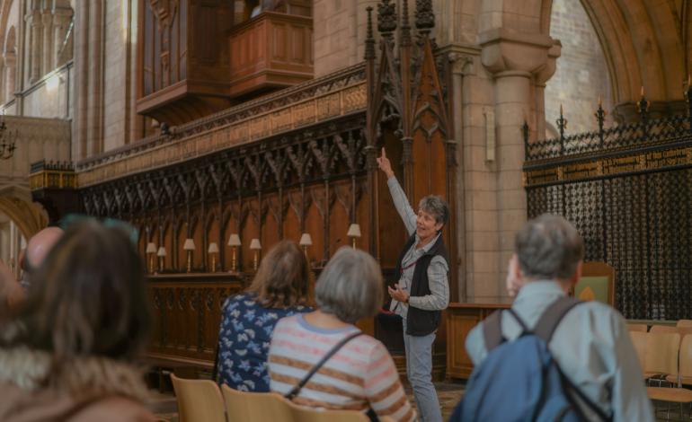 a volunteer guide giving a tour in the Quire