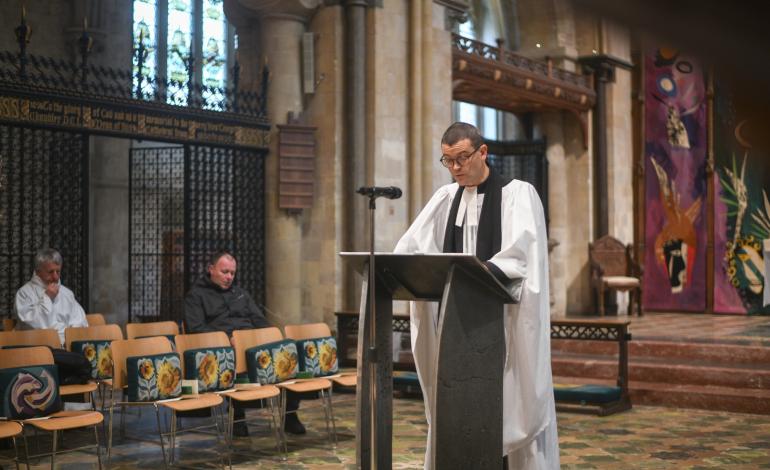 Canon Jack reads during a service