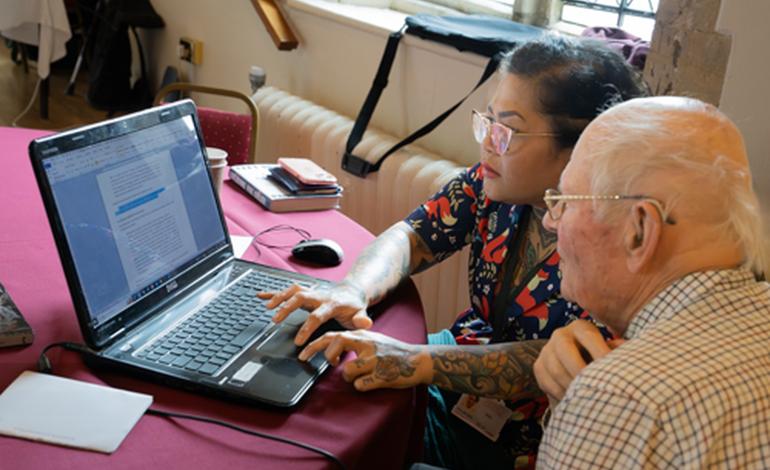 A digital helper assisting an attendee with their laptop