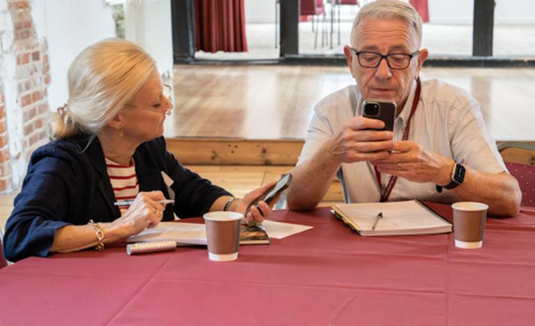 A digital helper assisting an attendee with their mobile phone