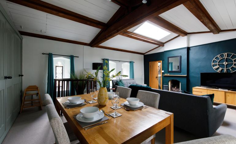 Dining area facing the living room, with a highchair and table settings for 4 people