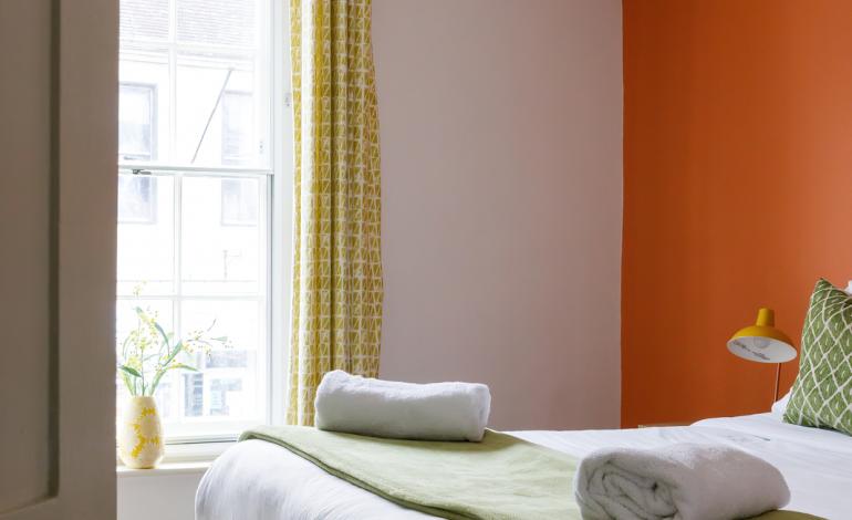 Second double bedroom, orange walls and green bedding