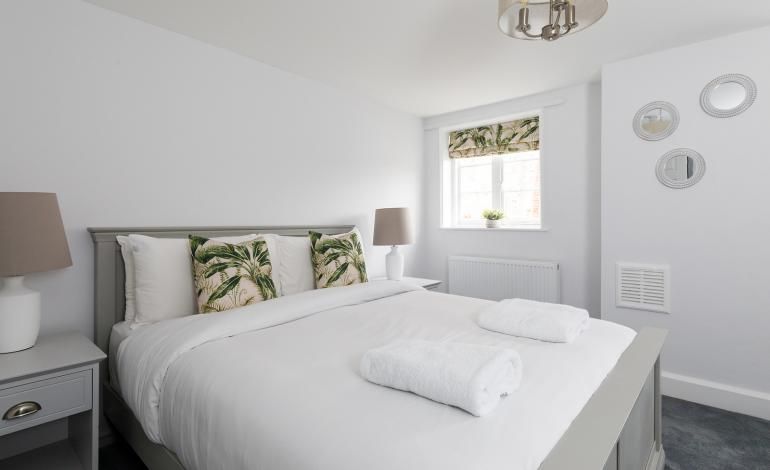 Double bedroom  1 decorated neutrally with green furnishings