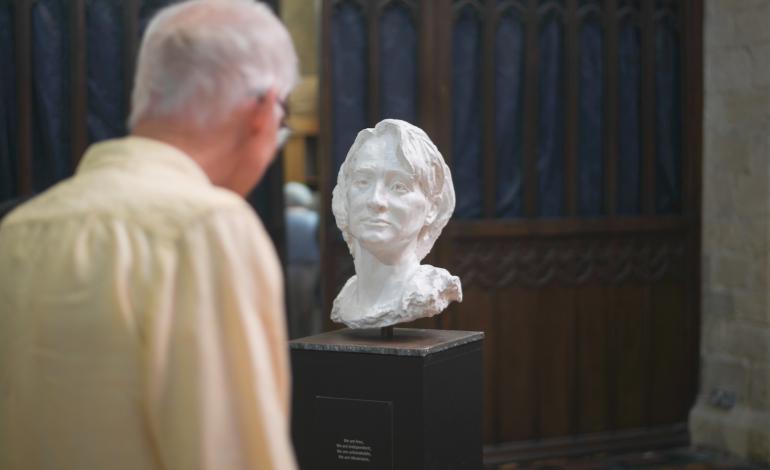 a visitor looks at a sculpture