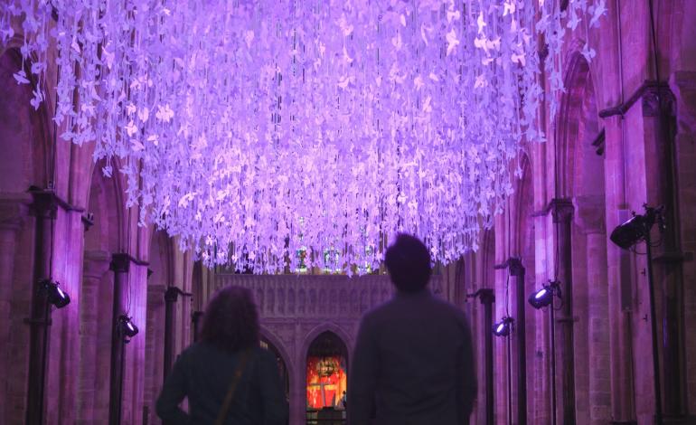 People stand infront of Peace Doves
