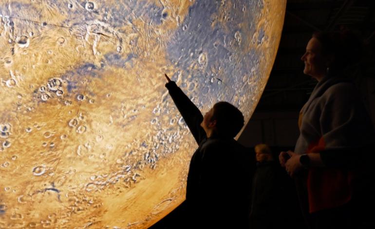 A child points at Mars
