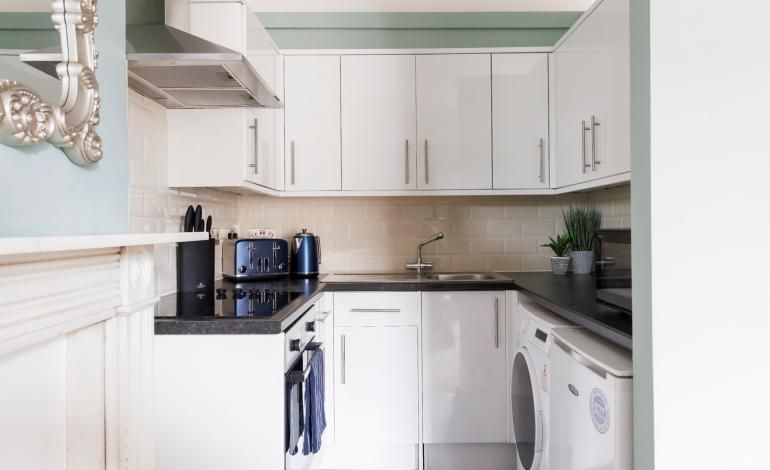 Kitchen view, kettle, toaster and washing machine.