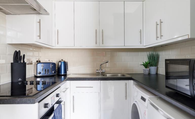 Kitchen view with kettle, microwave and oven.