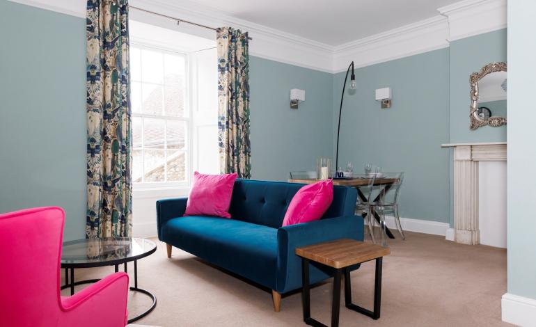 Sitting room with blue sofa and pink armchair. 