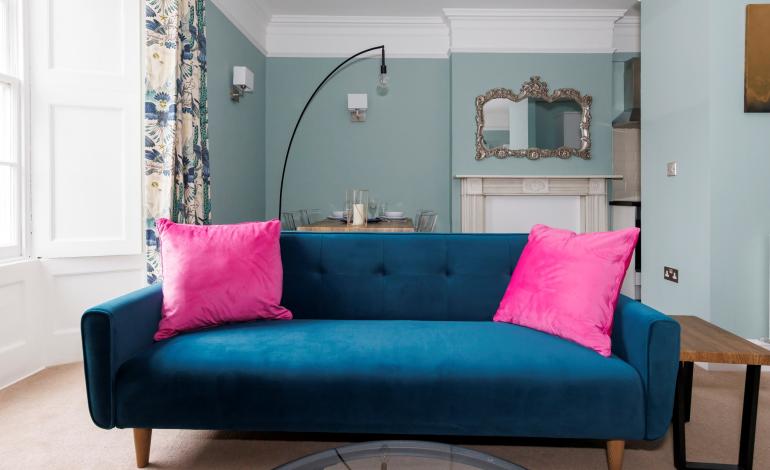 Blue sofa with pink cushions. 