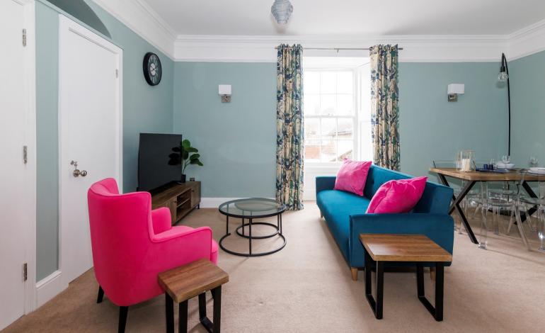 Wider shot of living and dining area with view of multimedia, sofa and dining table. 