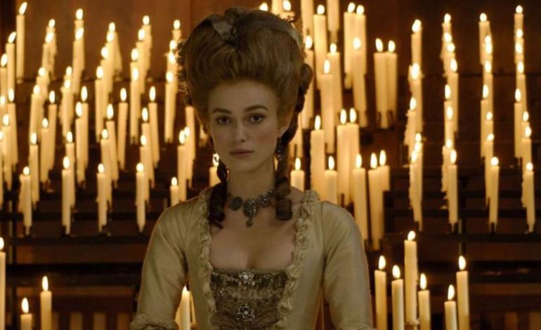The Duchess A woman standing in front of candles