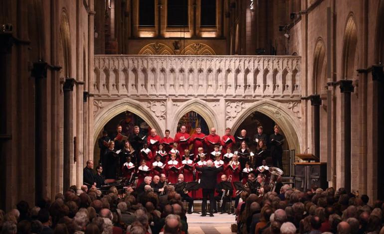 Chichester Cathedral's 2025 Fundraising Concert with Sir John Rutter A choir in front of Cathedral Architecture