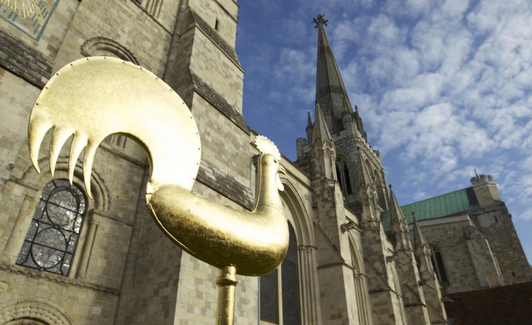 the cockerel weathervane coated with Fairtrade gold leaf seen with the cathedral's spire above