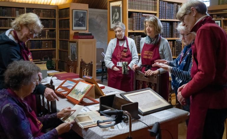 Cathedral librarians surround a table full of old books