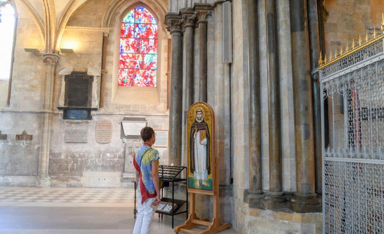 A volunteer looks at the mosaic