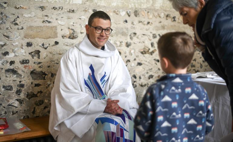 Canon Jack speaks to a young member of the congregation