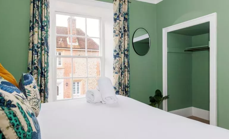 Bedroom wider view of storage and curtains, window and view