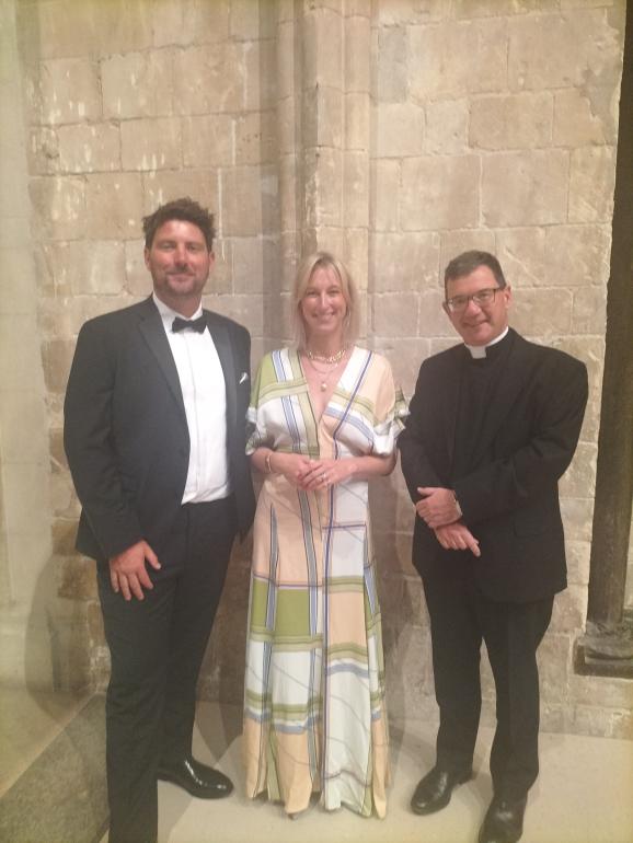 two men and a woman in evening clothes look to camera