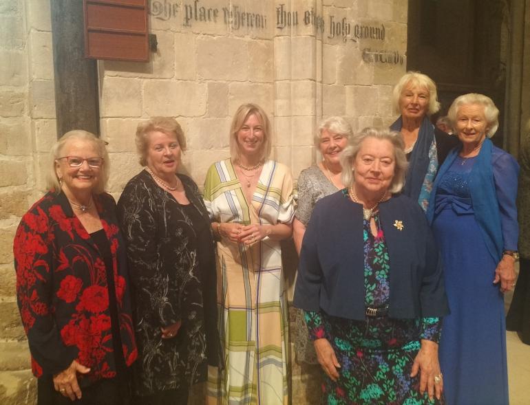 7 women in evening dress look to camera