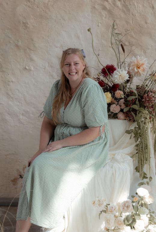 Photo of Hannah Howell amongst a flower arrangement, by Lucy Fergusson Photography